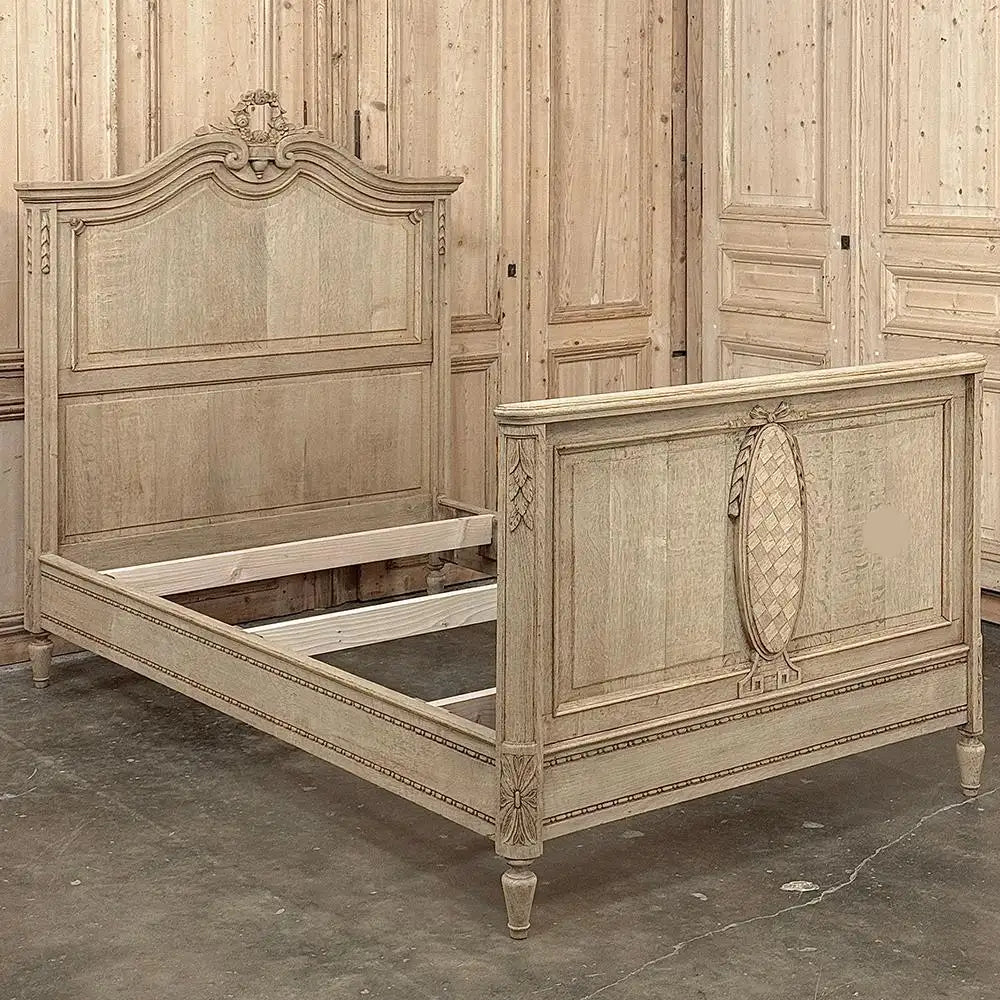 Vintage-style wooden bed with intricate carvings in a room with wooden paneling.
