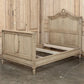 Wooden bed with intricate carvings in a room with wooden paneling.