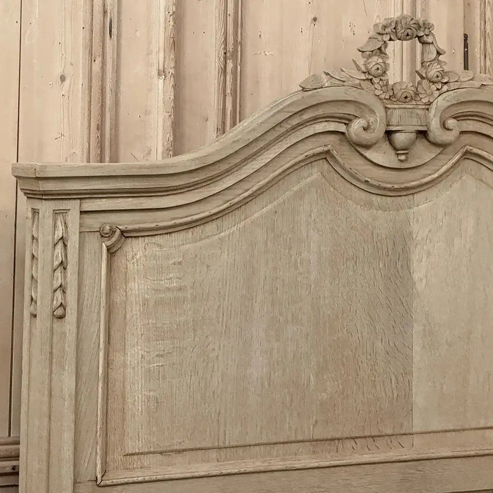Wooden headboard with decorative carvings and a wreath on top.