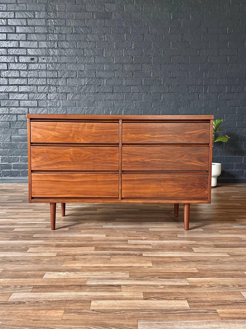 Wooden dresser against a gray brick wall on a wooden floor