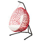 Red netted hanging chair with white cushion on a black stand against a white background