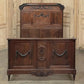 Vintage wooden dresser with intricate carvings in a room with paneled walls.