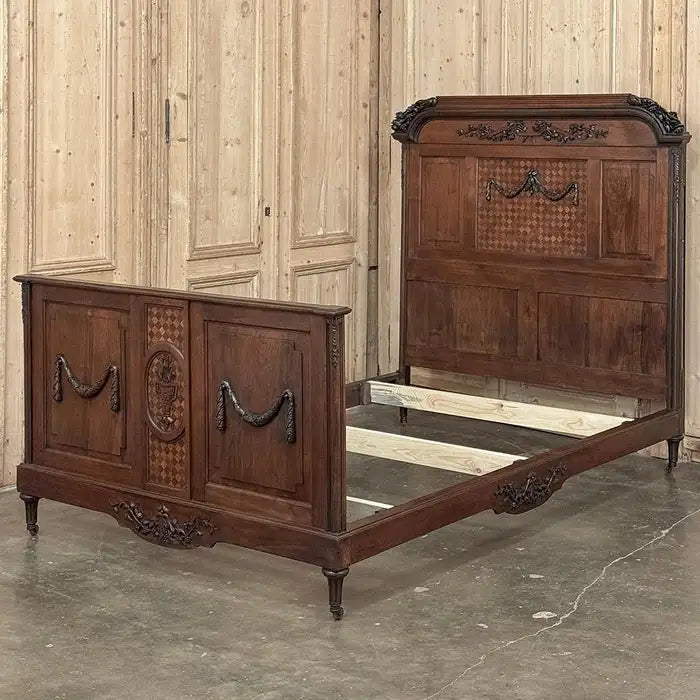Vintage wooden bed with intricate carvings in a room with wooden panel walls.