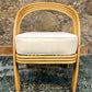 Beige chair with white cushion on a textured surface and stone wall background