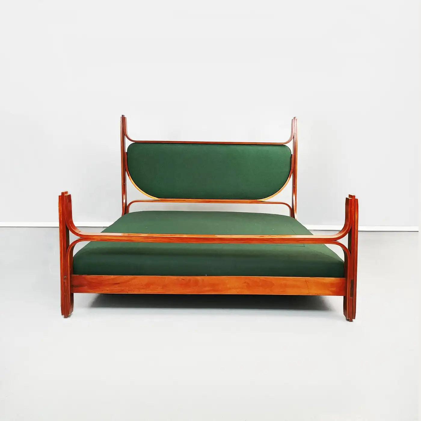 Bed with wooden frame and green mattress on a white background