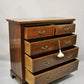 Wooden dresser with four drawers on a plain background