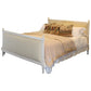 Bed with beige bedding and decorative pillows on a white background
