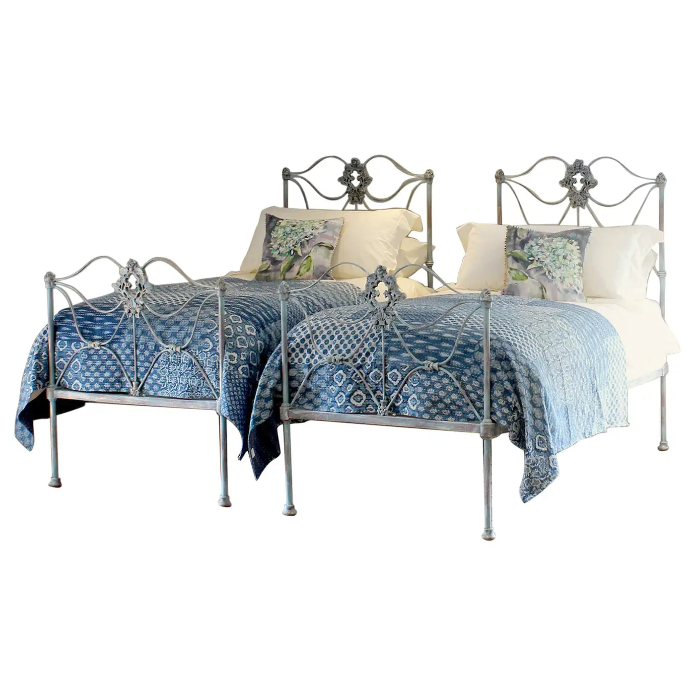 Decorative metal bed with blue patterned bedding on a white background
