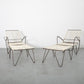 Pair of modern chairs with marble-like seats and metal frames on a plain floor.