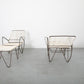 Modern outdoor furniture set with lounge chairs and table on a gray floor.
