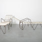 Modern outdoor furniture set with lounge chair and table on a gray floor.