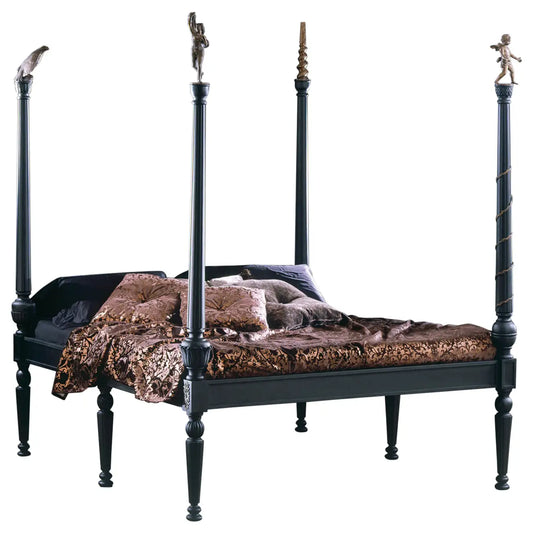 Decorative black four-poster bed with ornate finials and a patterned quilt on a white background