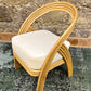 Wicker chair with a white cushion on a textured surface with a stone wall background