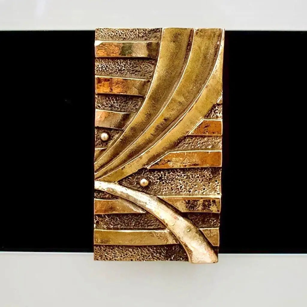 Decorative wall art with gold and bronze leaf design on a black background