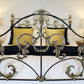 Decorative iron bed with gold accents in a bedroom setting