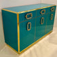 Teal cabinet with gold accents on a white background