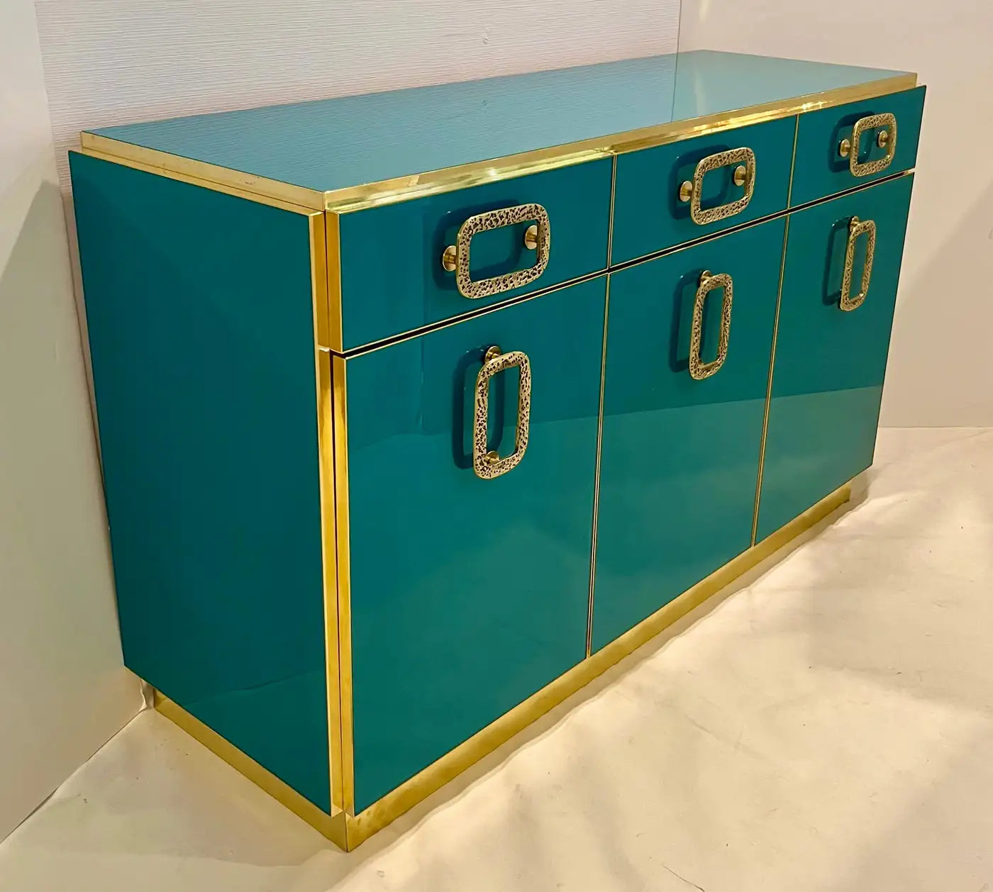 Teal cabinet with gold accents on a white background
