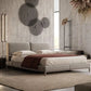 Modern bedroom with a gray upholstered bed and decorative wall art.