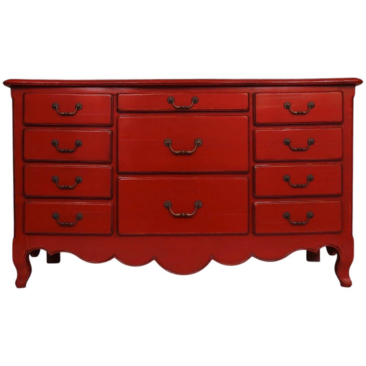 Red dresser with multiple drawers on a white background