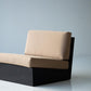 Modular sofa with beige cushions and black base on a plain background