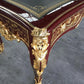 Decorative table with gold embellishments on a gray floor