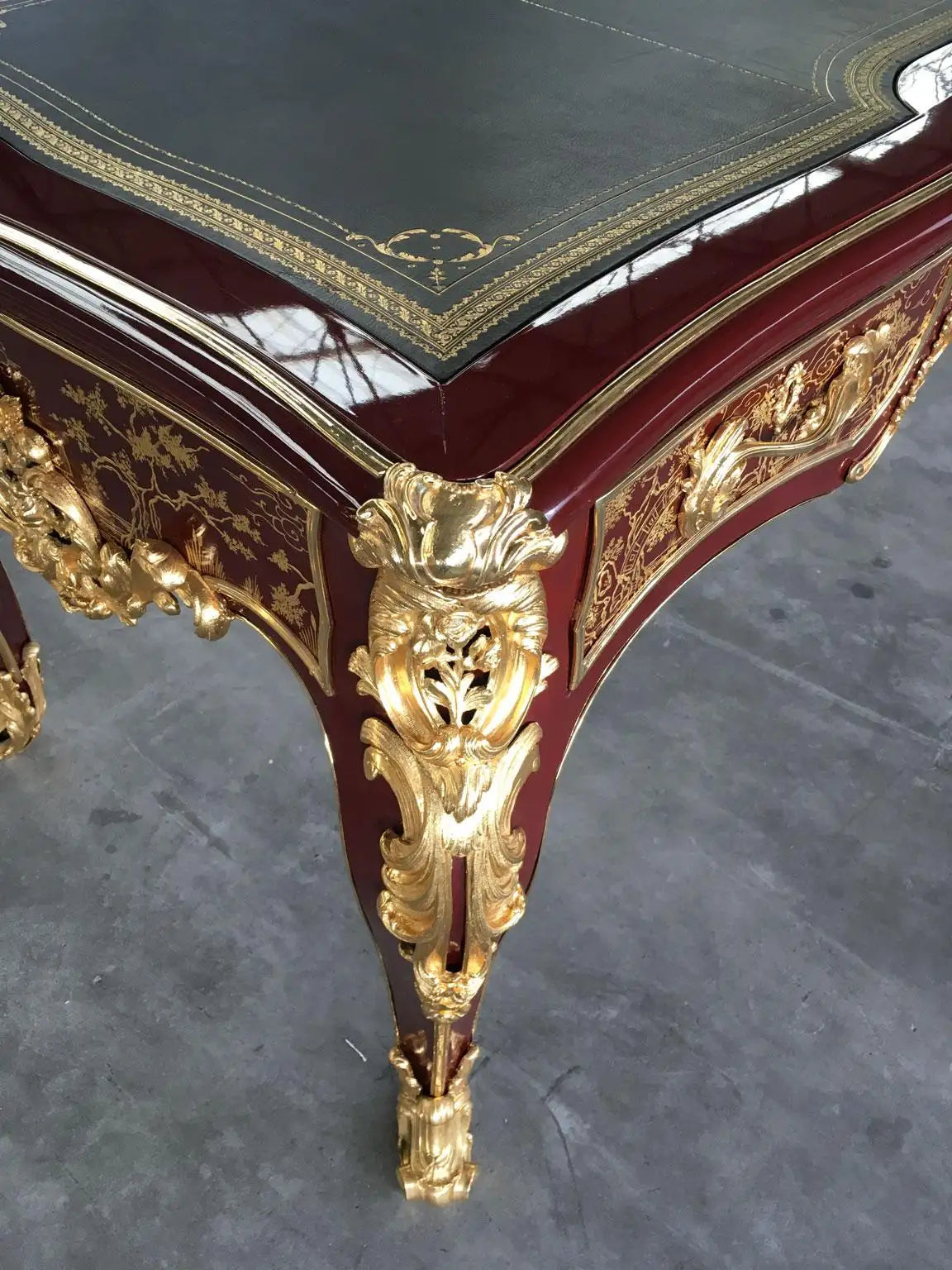 Decorative table with gold embellishments on a gray floor
