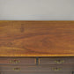 Wooden dresser with four drawers on a plain background
