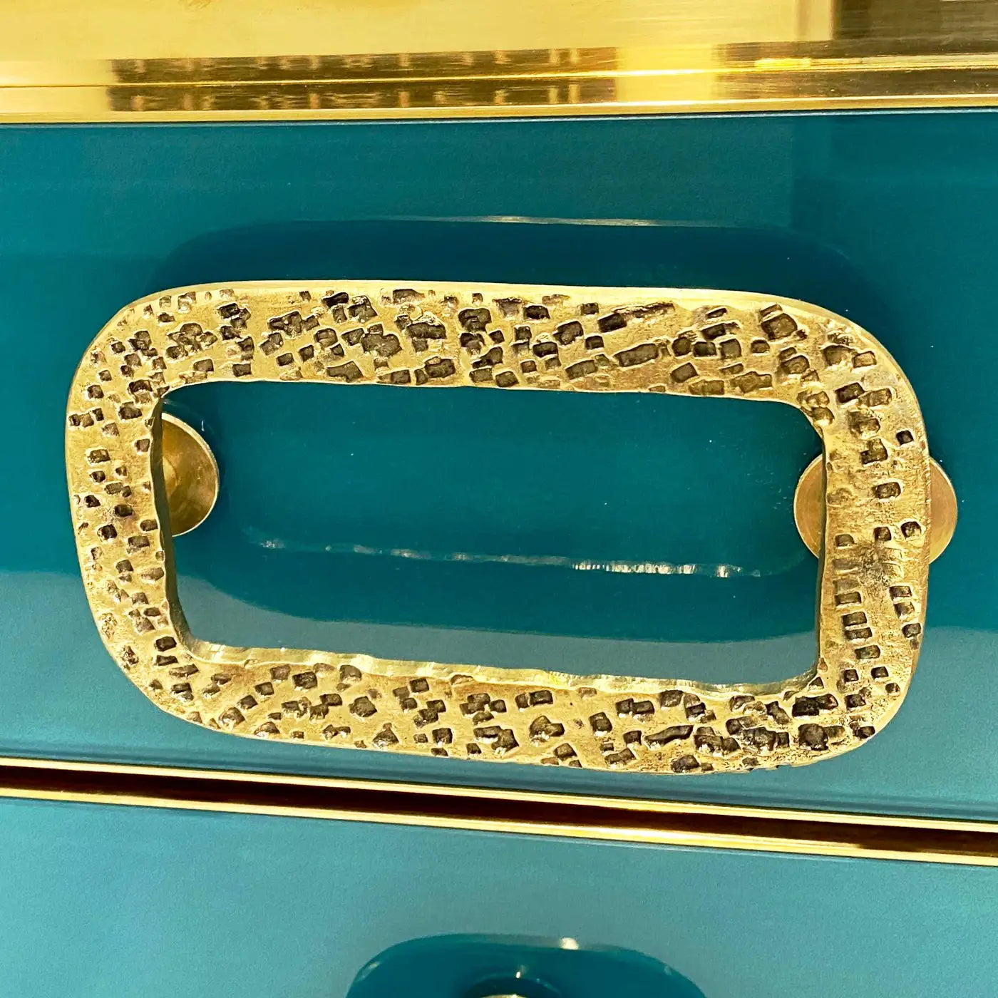 Gold textured handle on a teal background