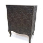 Decorative chest of drawers with intricate carvings on a white background