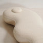 Beige U-shaped pillow on a light beige surface