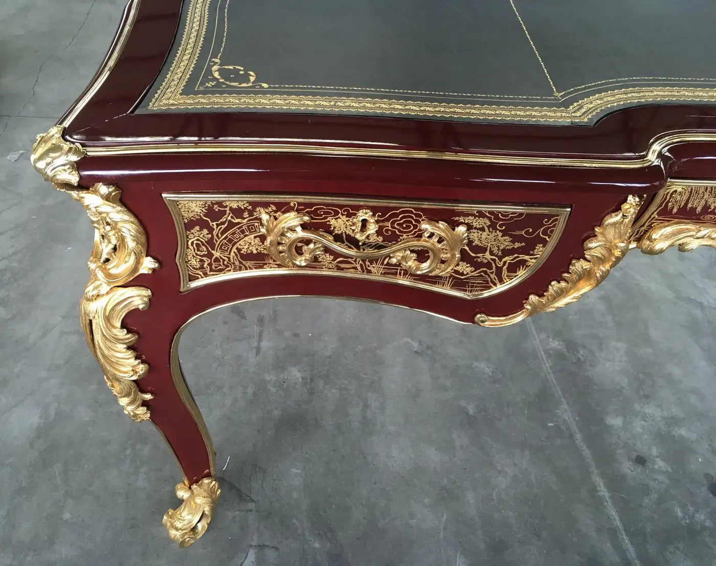Decorative table with gold embellishments on a gray floor
