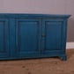 Blue wooden cabinet against a gray wall