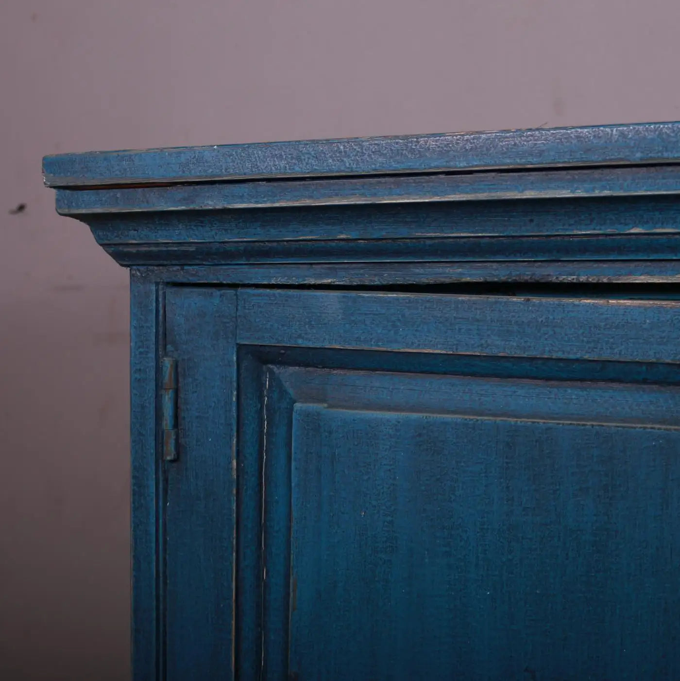 Close-up of a blue wooden cabinet with a gray background