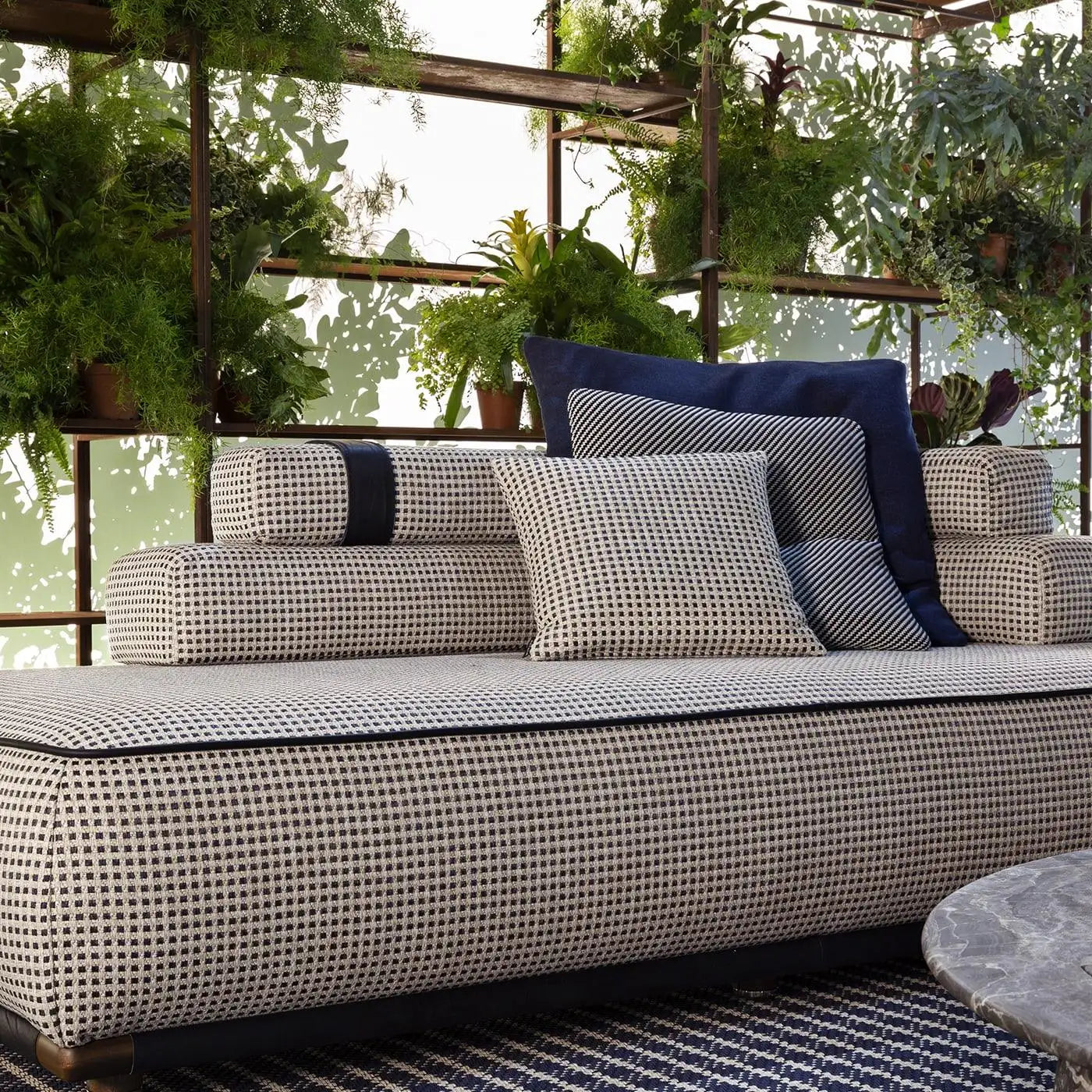 Outdoor sofa with patterned cushions in a garden setting