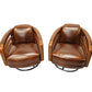 Pair of brown leather swivel chairs on a white background
