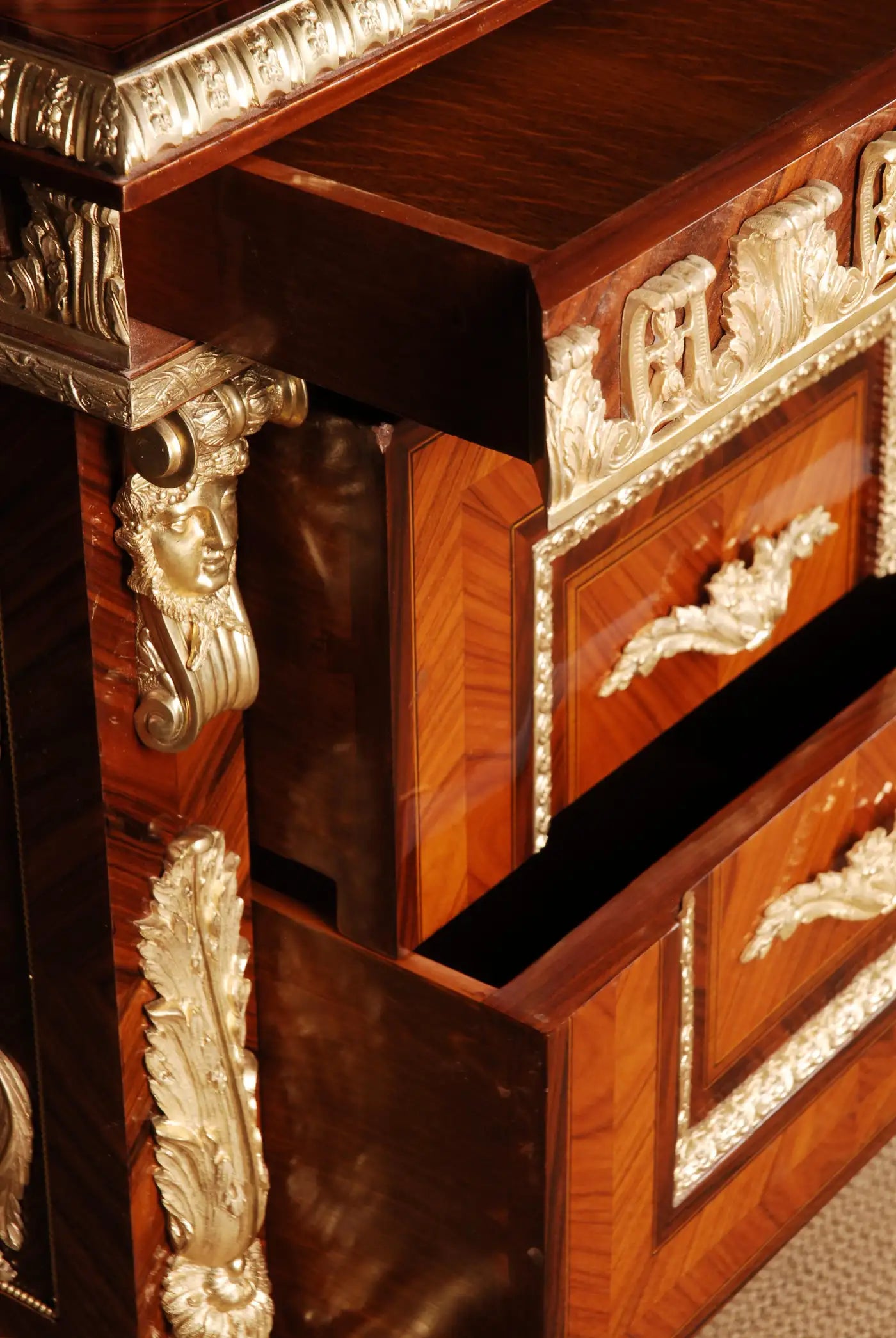 Close-up of a wooden cabinet with intricate carvings and gold accents