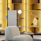 Modern white chair in a room with gold wall panels and decorative elements.