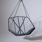 Hanging chair with geometric design on a plain background