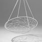 White hanging chair with geometric pattern on a gray background