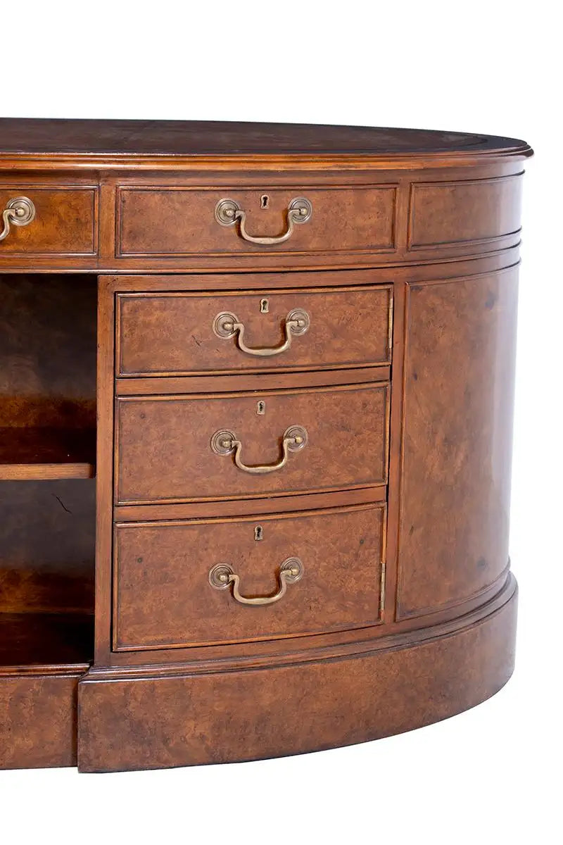 Close-up of a wooden desk with drawers and brass handles on a white background