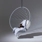 Hanging chair with a blanket and a small dog on a gray background