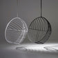 Two wireframe spherical chairs, one white and one black, on a gray background.