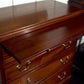 Wooden dresser with drawers and brass handles on a white background