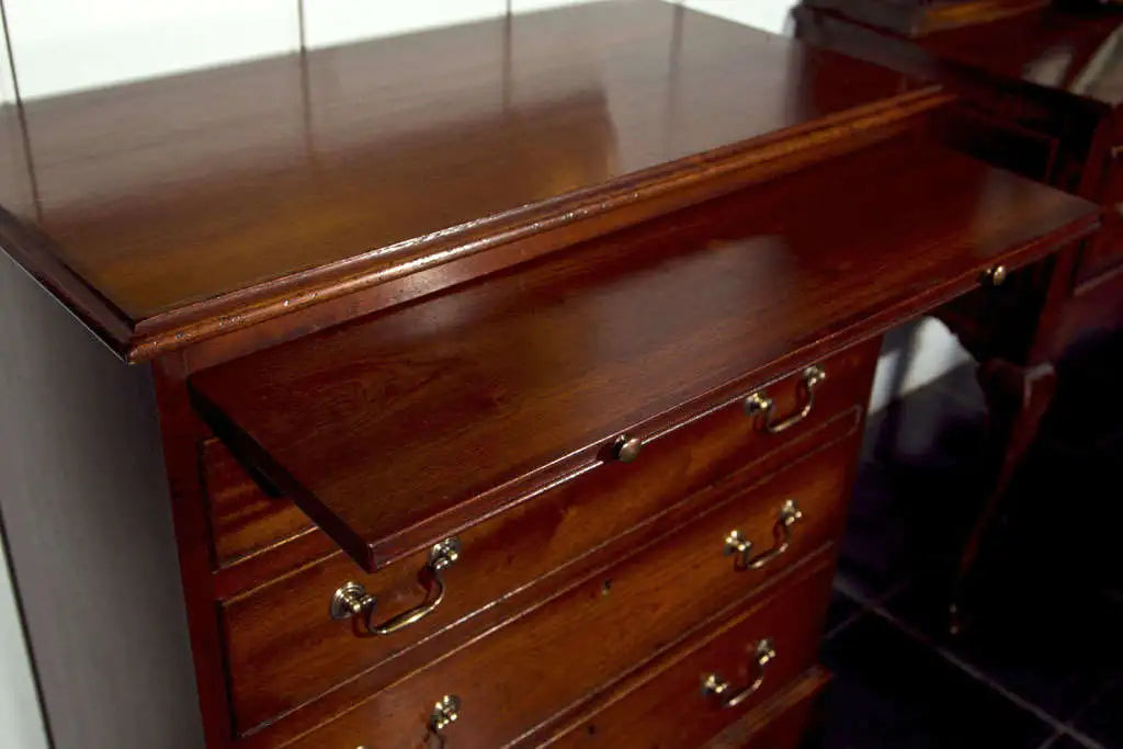 Wooden dresser with drawers and brass handles on a white background