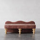 Pink velvet bench with wooden legs on a gray floor and light gray background