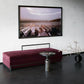 Modern interior with a pink bench, silver table, and decorative plant against a white wall.