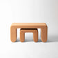 Two terracotta-colored stools on a white background