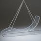 Modern white wire chair with curved design on a dark background