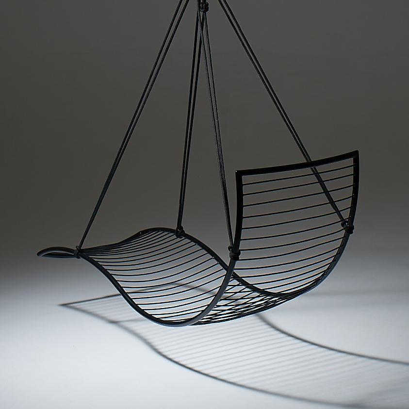 Black wire hanging chair on a dark background