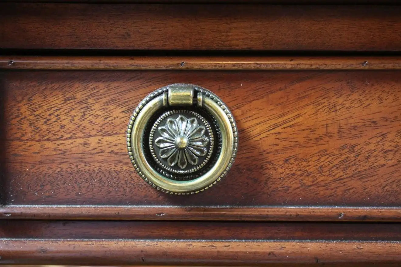 Close-up of a wooden drawer with a brass ring pull